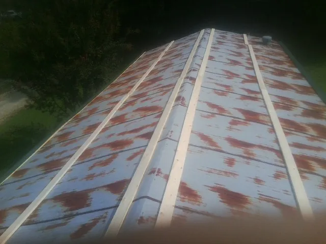 Rusted metal roof panels with new wood purlins before replacement — Storm Damage Roof Repair in Wynot by Roofing Brothers